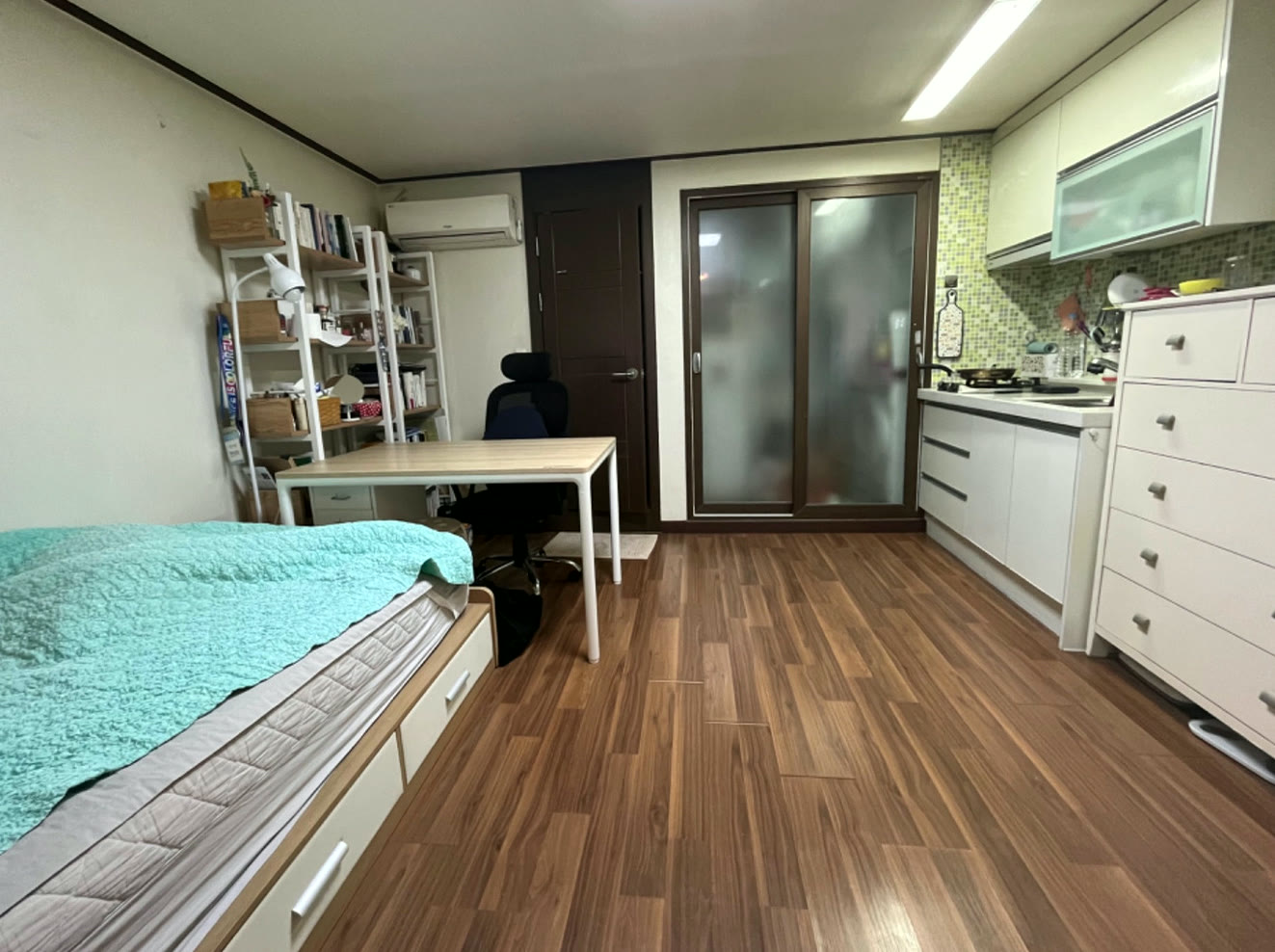 침대와 가까운 위치에 놓인 이동식 에어컨